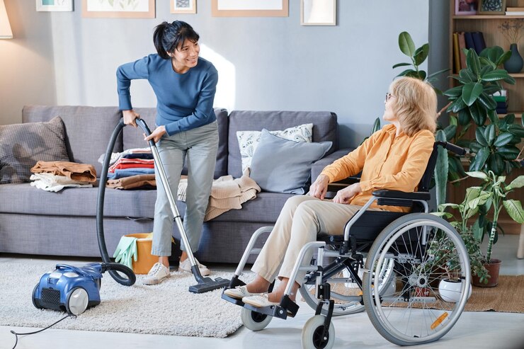 senior women using wheelchair talking housemaid who cleaning room he giving her instructions before ndis cleaning services